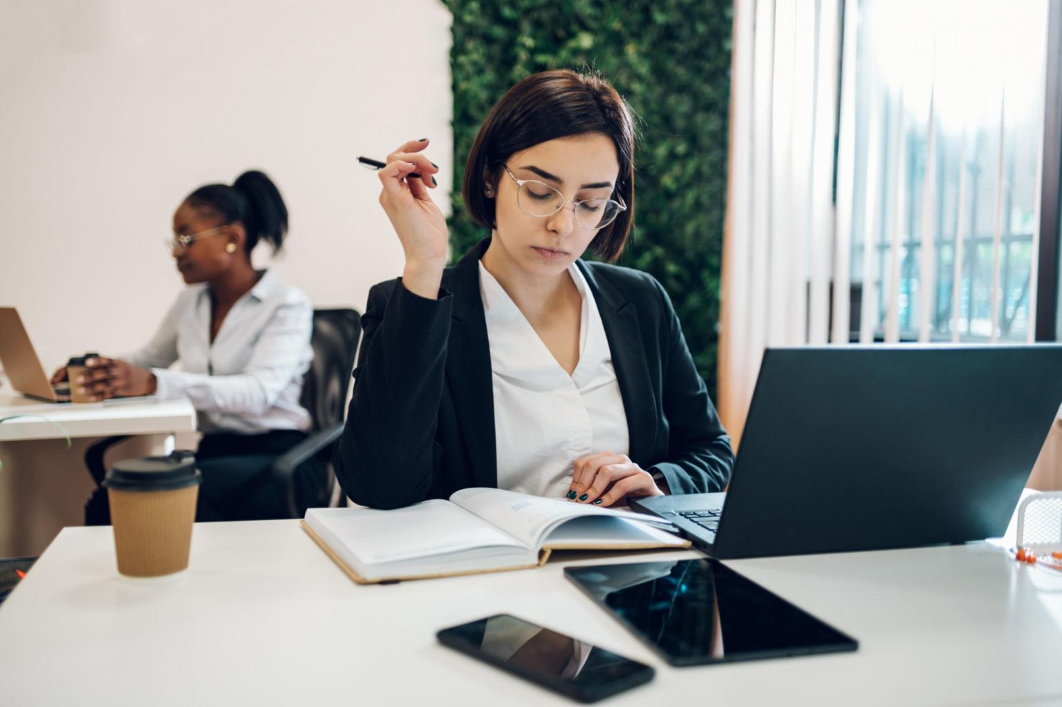 Entrepreneur travaillant sur un ordinateur portable dans un environnement de bureau moderne – délégation administrative et organisation d’entreprise