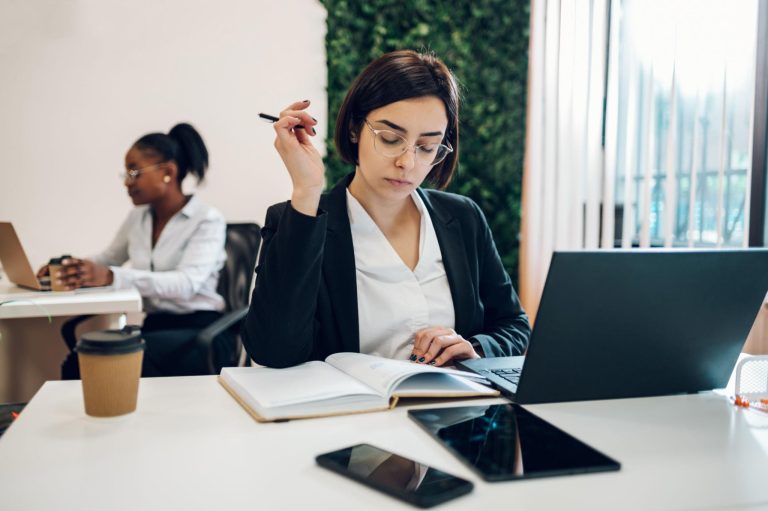 Entrepreneur travaillant sur un ordinateur portable dans un environnement de bureau moderne – délégation administrative et organisation d’entreprise